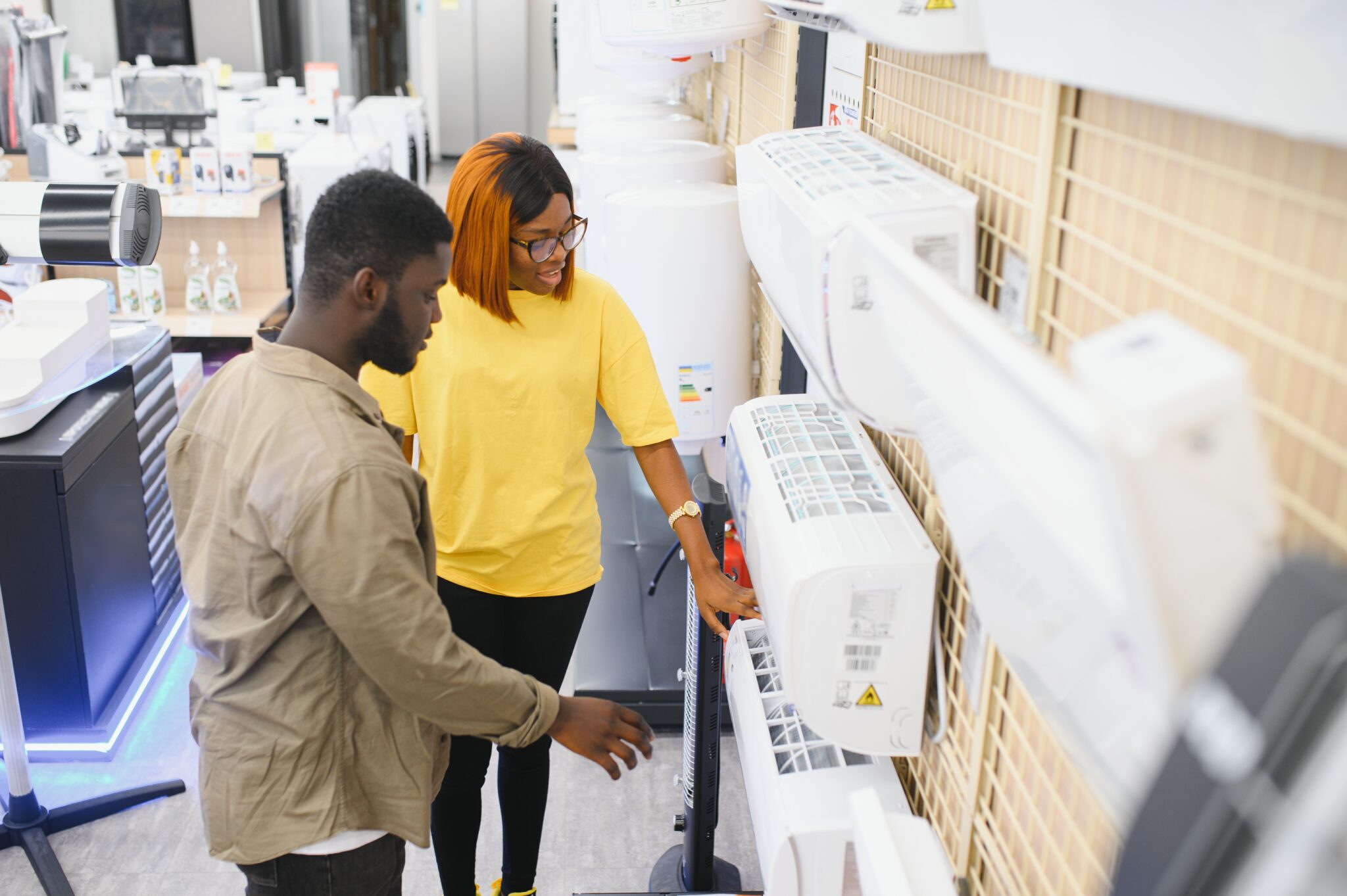 an african american man and woman choose an air conditioner in an electronics store