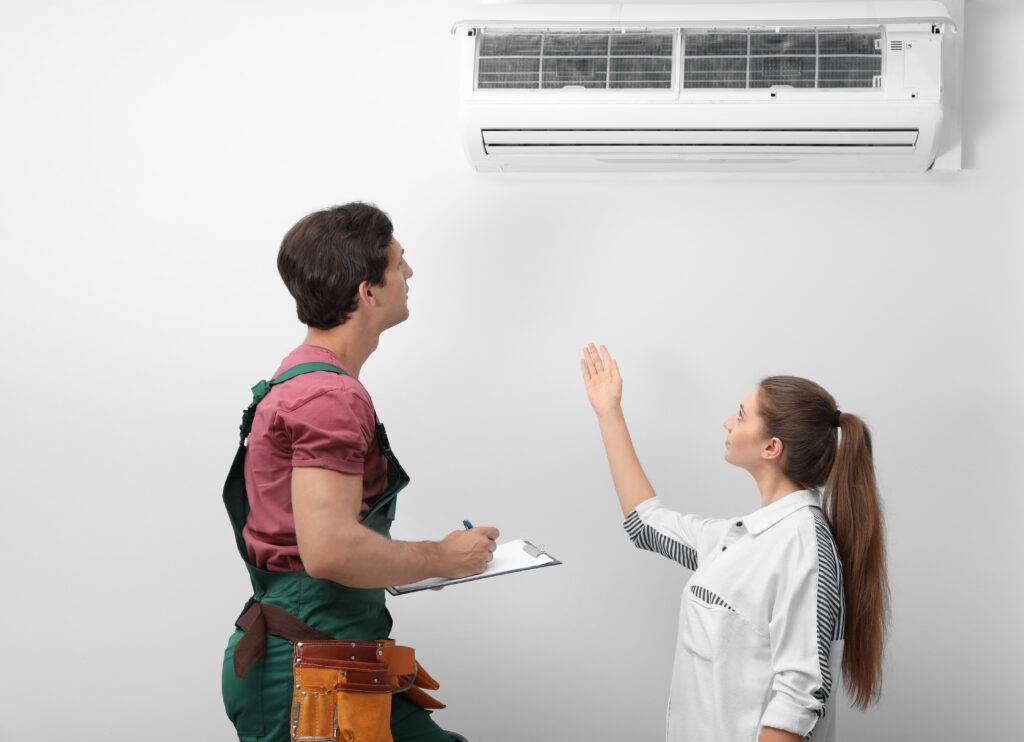 male technician speaking with woman about air conditioner indoors