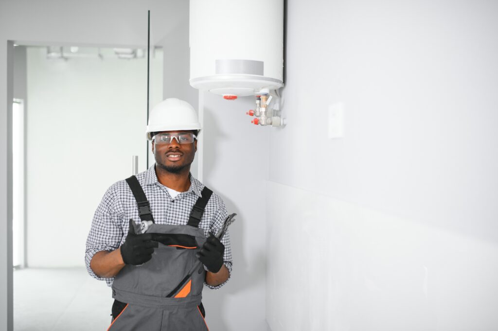 young african male plumber repairing boiler